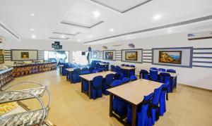 a dining room with blue chairs and tables at Treebo Trend MP Inn in Raipur