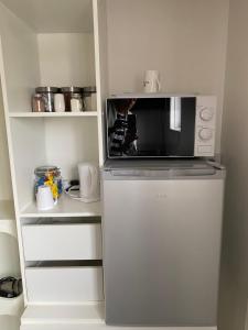 a microwave on top of a refrigerator in a kitchen at Quiet, spacious double bedroom! in Peterborough