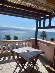 una mesa en un balcón con vistas al océano en Blue Eden Strait, en Messina