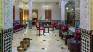 a lobby with tables and chairs in a building at Riad Des Nations in Marrakesh