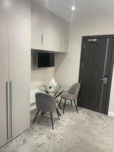 a kitchen with a table and two chairs and a refrigerator at Park Avenue Hotel in London