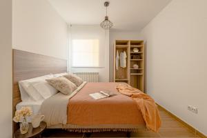 a bedroom with a bed with an orange blanket at Estilo japandi Sardinero in Santander