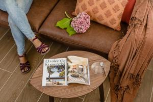 uma pessoa sentada num sofá com um livro sobre uma mesa em Estilo japandi Sardinero em Santander