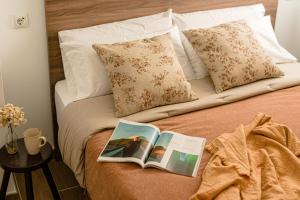 a bed with a book and pillows on it at Estilo japandi Sardinero in Santander