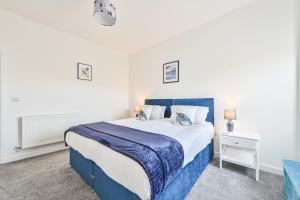 a bedroom with a blue and white bed and a nightstand at The Falstone Apartment in Torquay