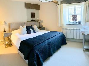a bedroom with a large bed with a blue blanket at The Owlery At Aysgarth in Aysgarth