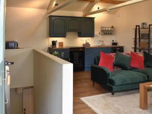 a living room with a couch and a kitchen at The Owlery At Aysgarth in Aysgarth