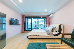a bedroom with a bed and a large window at Gangneung Haesolnaeeum Pension in Gangneung