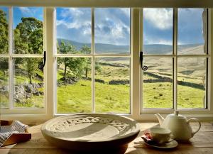 a large bowl sitting on a table in front of a window at Crina Bottom - Offgrid Mountain Escape in the Yorkshire Dales National Park in Ingleton