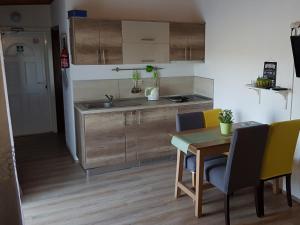 a kitchen with a table and yellow chairs in a room at Apartments Snježana Carev in Jezera