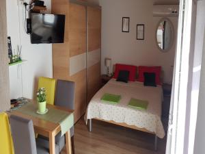 een slaapkamer met een bed, een tafel en een televisie bij Apartments Snježana Carev in Jezera