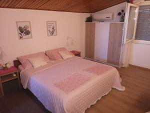 een slaapkamer met een bed met roze kussens erop bij Apartments Snježana Carev in Jezera