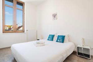 - un lit blanc dans une chambre blanche dotée d'une fenêtre dans l'établissement Le Manoir de Cyrielle - WIFI - 20 min centre ville de Strasbourg, à Bischheim