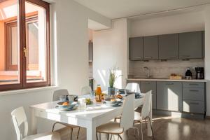 - une cuisine avec une table blanche et des chaises blanches dans l'établissement Le Manoir de Cyrielle - WIFI - 20 min centre ville de Strasbourg, à Bischheim