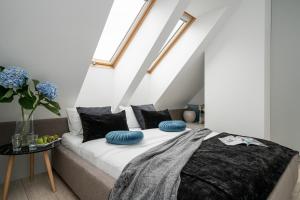 ein Schlafzimmer mit einem Bett mit blauen Kissen darauf in der Unterkunft AbsyntApartments 24 Rynek Wrocław - MAMY WOLNE POKOJE ! in Breslau
