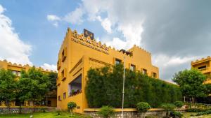 a yellow building with trees on the side of it at Hamlinn Resort in Guna