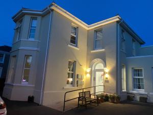 a white house with a gate in front of it at The Falstone Apartment in Torquay