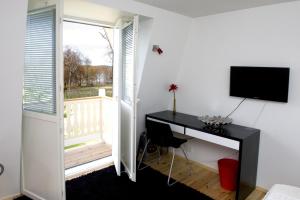 a room with a desk and a television and a window at Vohloisten Kartano in Lohja