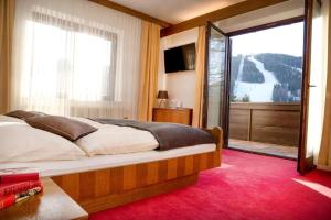 ein Schlafzimmer mit einem großen Bett und einer Glasschiebetür in der Unterkunft Haus Kohl in Semmering