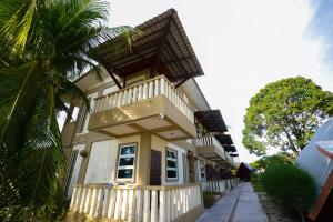 une maison avec un balcon et un palmier dans l'établissement Delta Chenang Resort, à Pantai Cenang