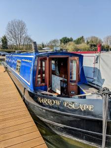 トリングにあるNarrow Escape - 50ft Boat on the Grand Union Canal, near Tringの青い船が桟橋の横に停泊