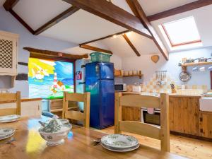 a kitchen with a wooden table and a blue refrigerator at New England-uk12750 in Menheniot
