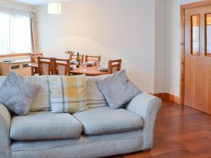 a living room with a couch and a dining room at Glen Apartment in Aviemore