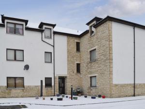a large brick building with windows at Glen Apartment in Aviemore