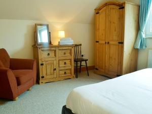 a bedroom with a bed and a dresser with a mirror at Cressfield Villa in Ecclefechan