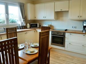 a kitchen with a wooden table and chairs and a table and chairsktop at Cressfield Villa in Ecclefechan