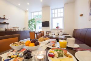 a breakfast table with food and drinks on it at Hotel Herzog in Düsseldorf
