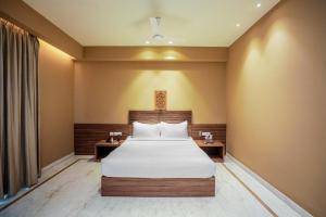 a hotel room with a bed and two tables at Gulab Kothi by Royal Orchid Hotels Limited Varanasi in Varanasi