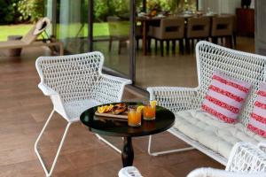 duas cadeiras e uma mesa com uma bandeja de comida em StayVista at Bella Aquila with Pvt Pool & Lawn - Parra NorthGoa em Anjuna