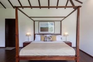 uma cama de dossel num quarto com 2 candeeiros em StayVista at Bella Aquila with Pvt Pool & Lawn - Parra NorthGoa em Anjuna