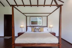 a canopy bed in a bedroom with two lamps at StayVista at Bella Aquila with Pvt Pool & Lawn - Parra NorthGoa in Anjuna
