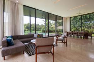 a living room with a couch and chairs and a table at StayVista at Bella Aquila with Pvt Pool & Lawn - Parra NorthGoa in Anjuna