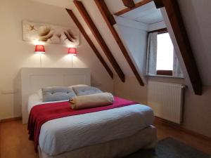 a bedroom with a bed with a red blanket at Victor et Léontine in Ribeauvillé