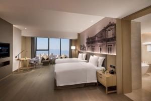 Voodi või voodid majutusasutuse Wyndham Grand Plaza Royale Yuzhou Xiamen Wuyuan Bay toas