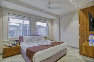 a bedroom with a large bed and windows at Hotel Pavilion in Indore