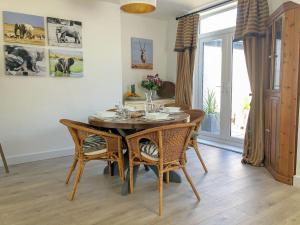 a dining room with a wooden table and chairs at May Escape in Heswall