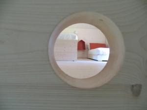 ein Spiegel an einer Wand neben einem Bett in einem Zimmer in der Unterkunft Quader Nidi nel Verde Authentic Farm Stay in the Italian Alps in Bienno + 43 Fotos