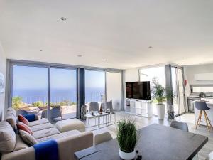 a living room with a couch and a tv at Villa Piece of Heaven by LovelyStay in Estreito da Calheta