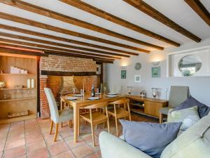 a living room with a table and chairs and a kitchen at Rose Cottage in Reedham