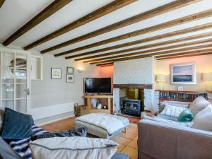 a living room with a couch and a fireplace at Rose Cottage in Reedham