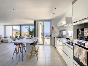 a kitchen with a kitchen island with a view of the ocean at Villa Piece of Heaven by LovelyStay in Estreito da Calheta