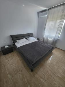 a bedroom with a bed with a black comforter and a window at Vila Darimar Chișoda in Chişoda