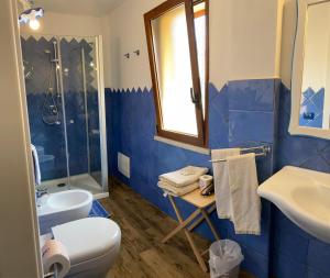 Baño azul con aseo y lavamanos en B&B da Miranna, en Dorgali