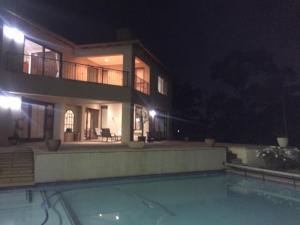 a large house with a swimming pool at night at Views for Africa in Johannesburg