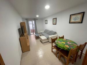 ein Wohnzimmer mit einer Couch und einem Tisch und Stühlen in der Unterkunft Apartamento colón arinaga in Arinaga