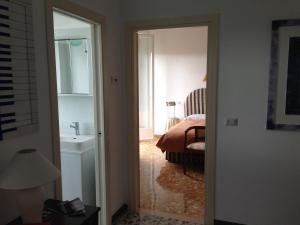 a bedroom with a bed and a bathroom with a sink at A Casa di Ilaria in Fermo
